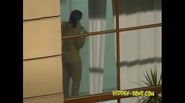 HD A girl washes in the shower, and we see her through the window drive Clips